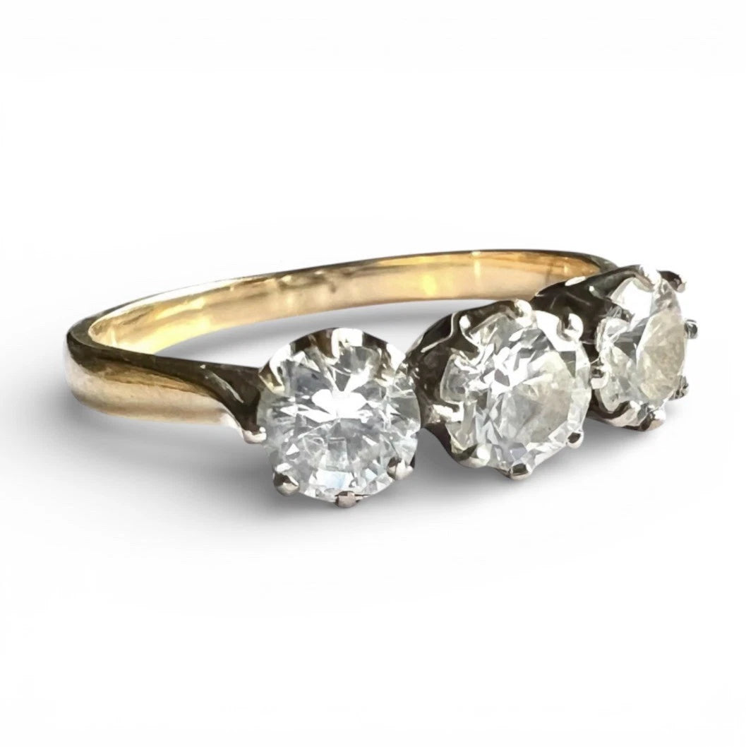 Gold ring with three large cubic zirconia on a white background close up 