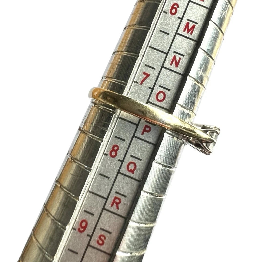 Close-up of a silver measuring tool with gold ring on a white background