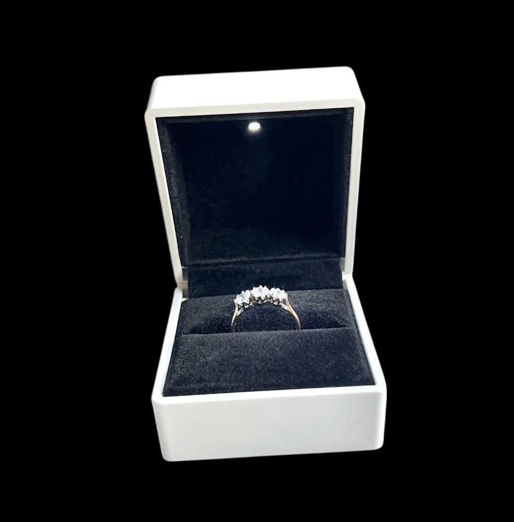 Diamond ring in an open white jewellery box on a black background