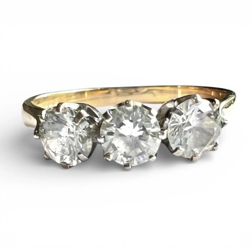 Gold ring with three large cubic zirconia on a white background close up front view 