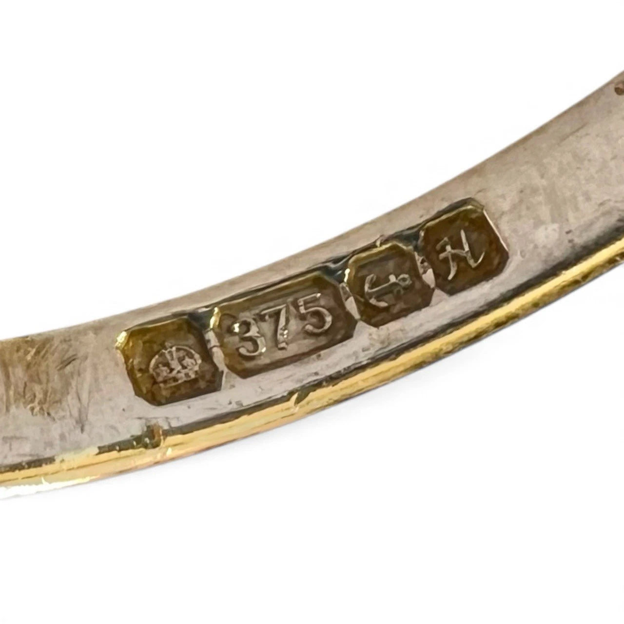 Close-up of a gold ring hallmarks on a white background