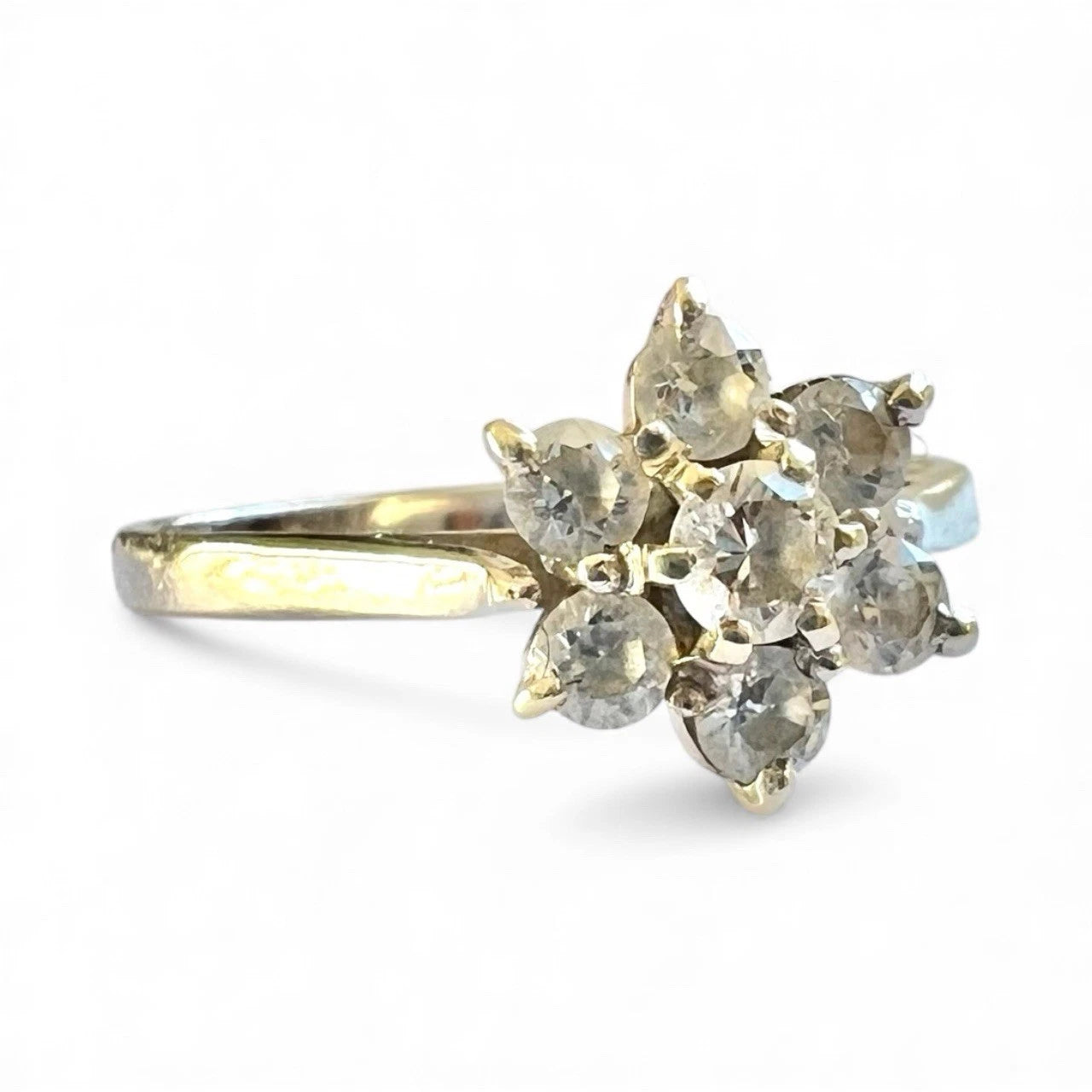 Gold ring with multiple cubic zirconia on a white background