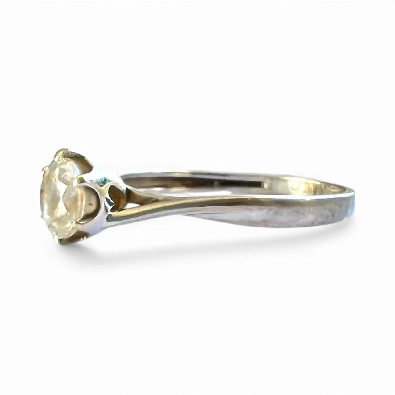 White Gold ring with a CZ on a white background, close up side view of setting 