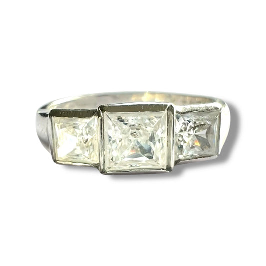 White gold ring with three square-cut cubic zirconia on a white background