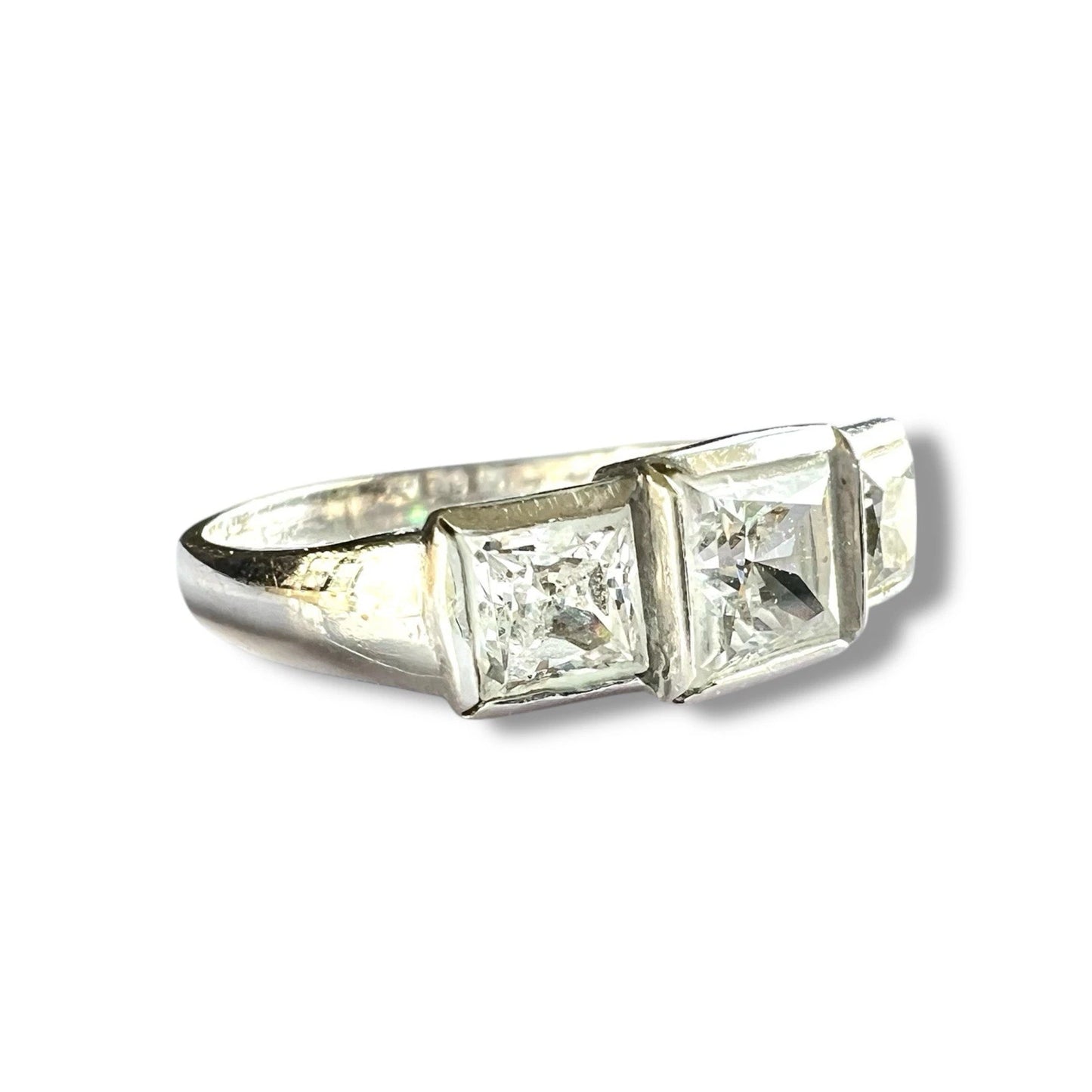 Diamond ring with three square-cut cubic zirconia on a white background