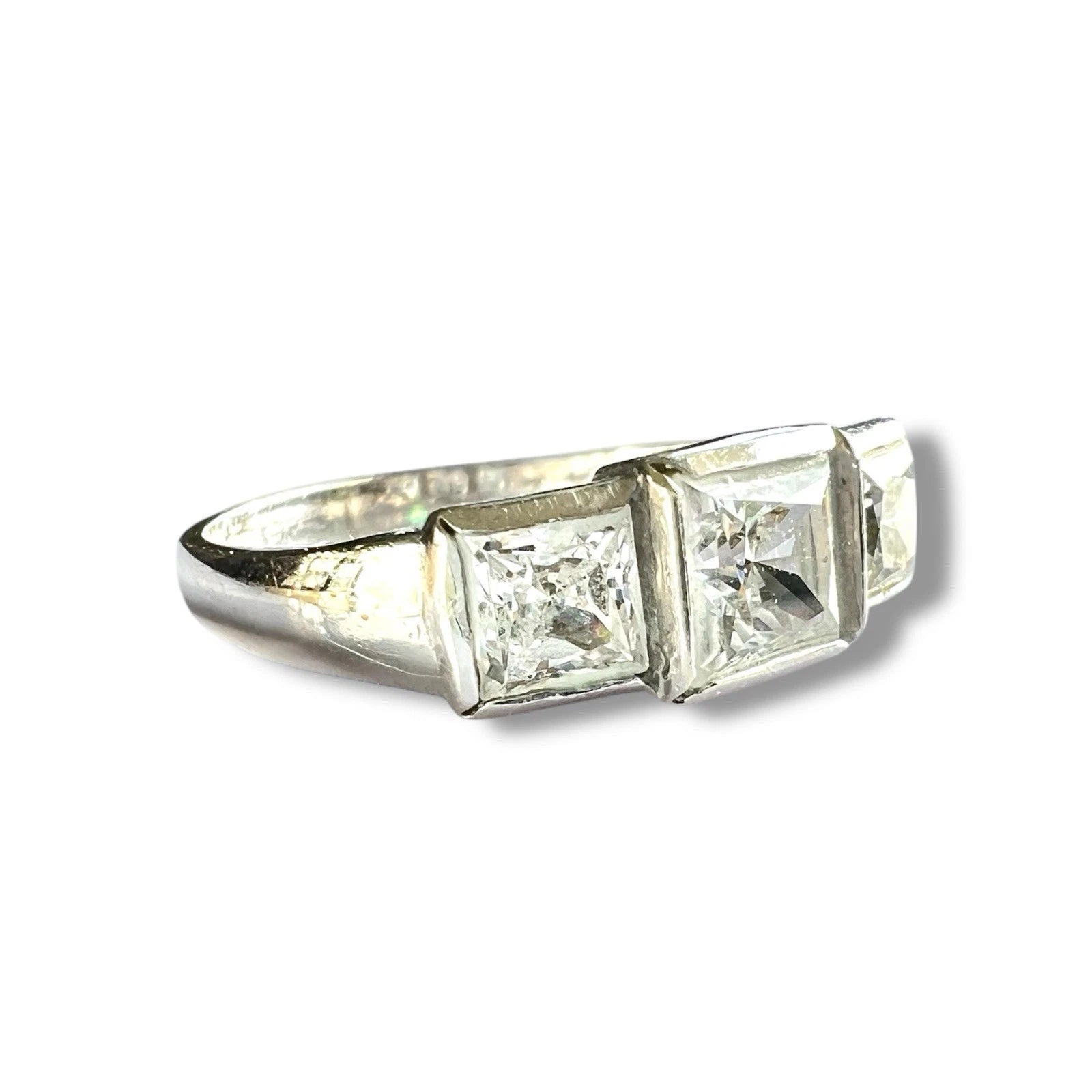 Diamond ring with three square-cut cubic zirconia on a white background