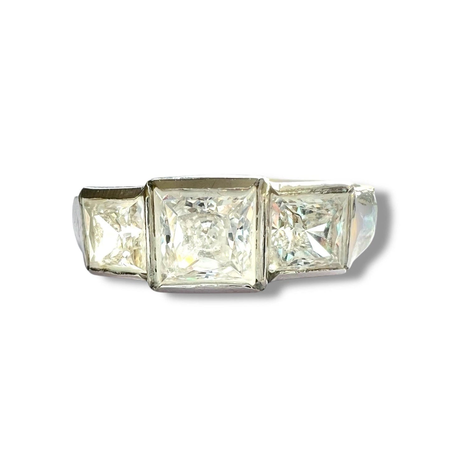 Three-stone ring with square-cut cubic zirconia on a white background