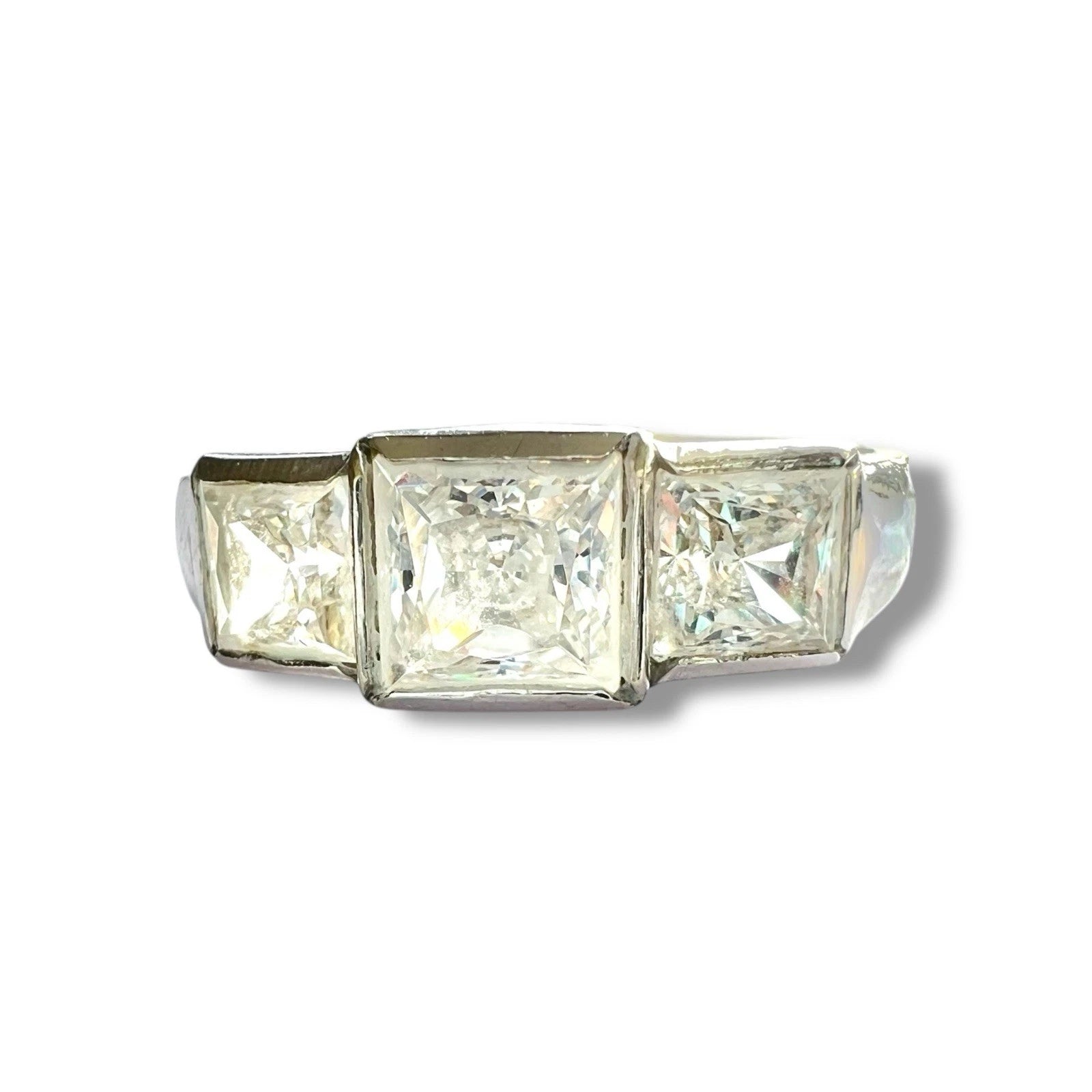 Three-stone ring with square-cut cubic zirconia on a white background