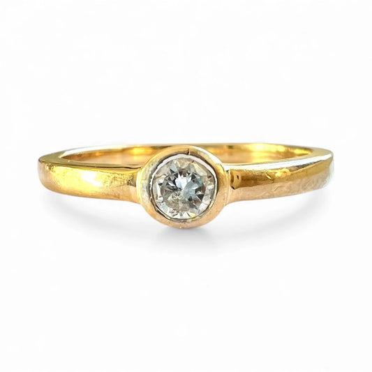 Gold ring with a cubic zirconia on a white background