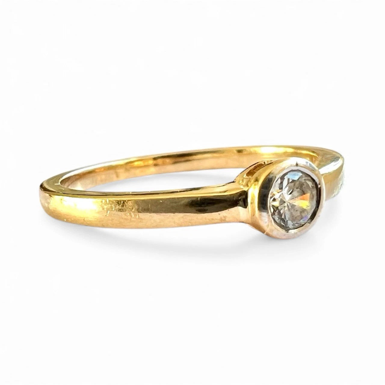 Gold ring with a cubic zirconia on a white background