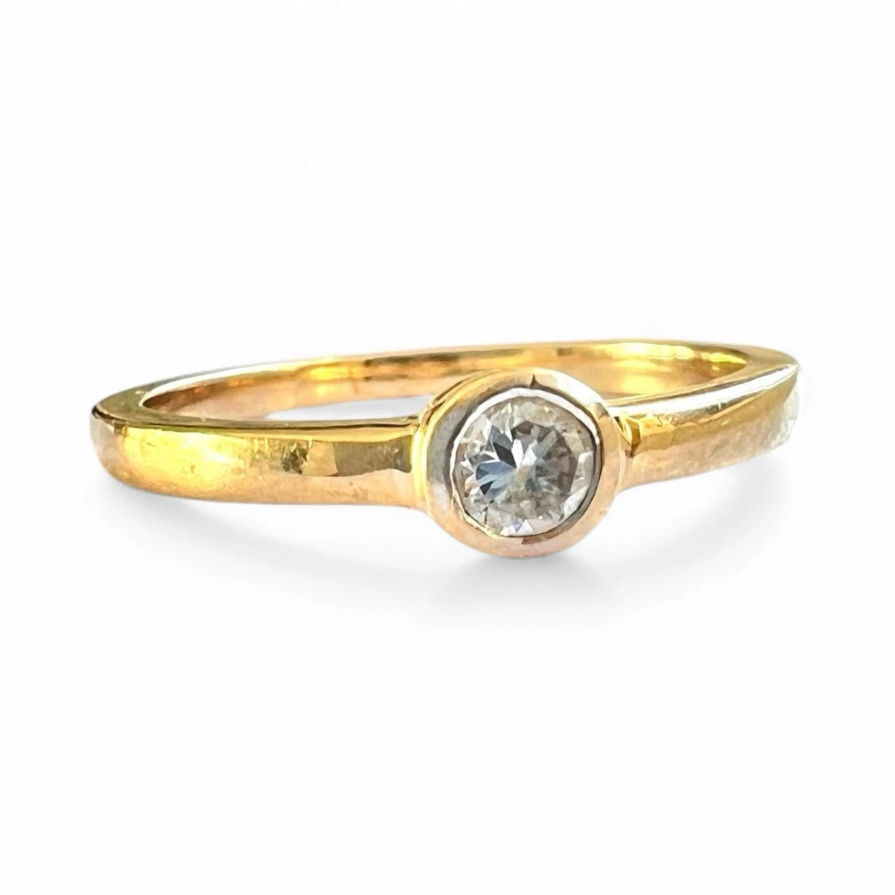 Gold ring with a cubic zirconia on a white background