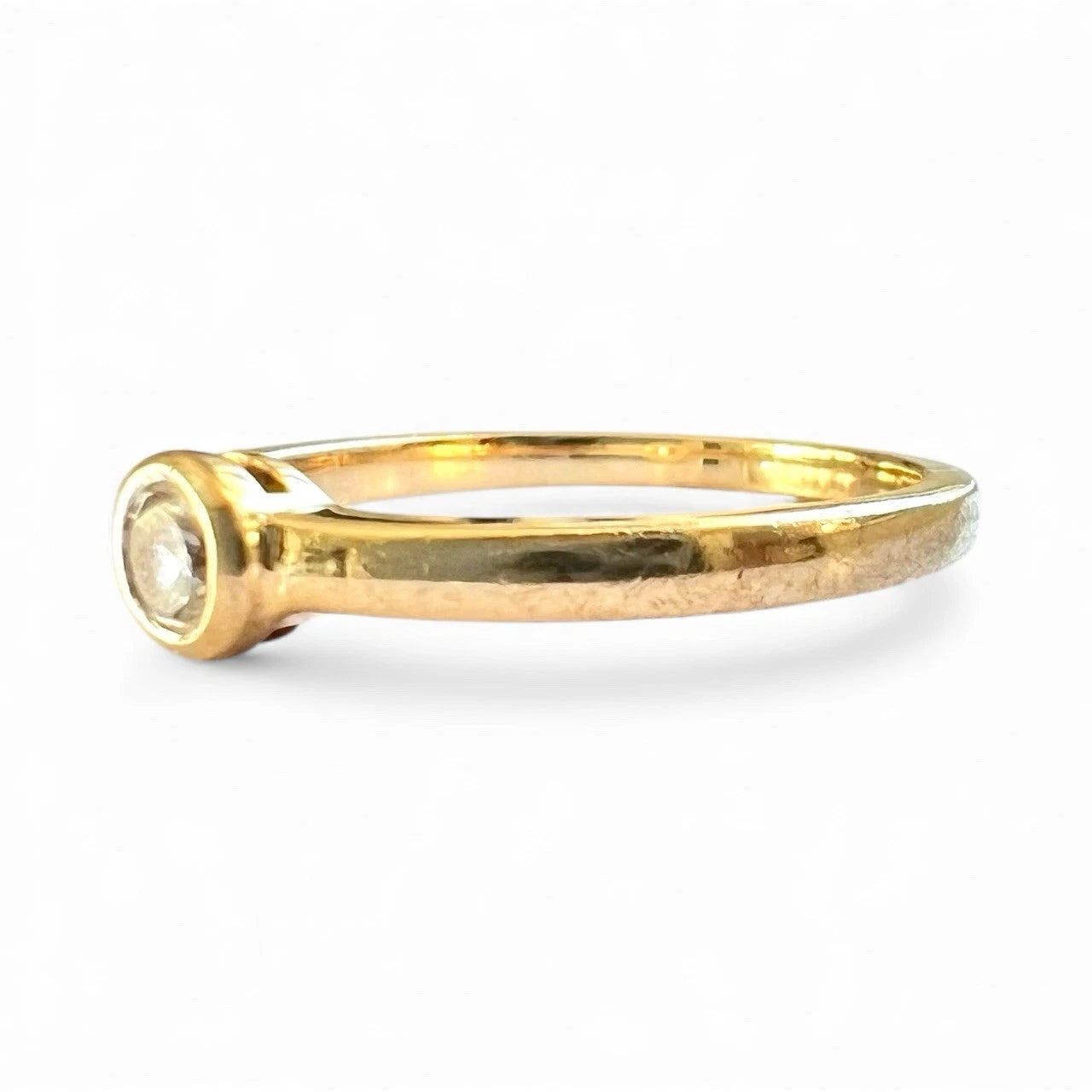 Gold ring with a cubic zirconia on a white background