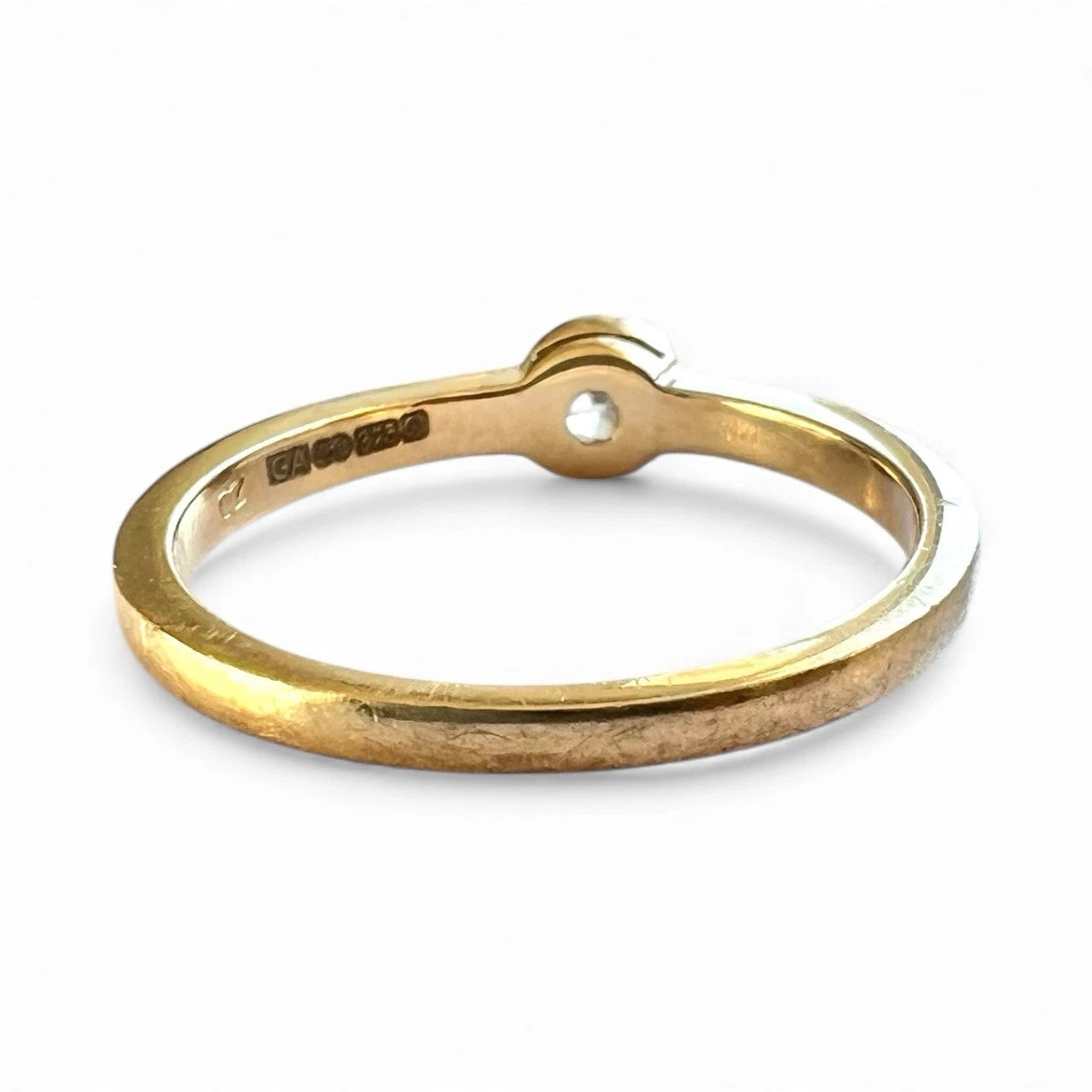 Gold ring with visible hallmark on a white background