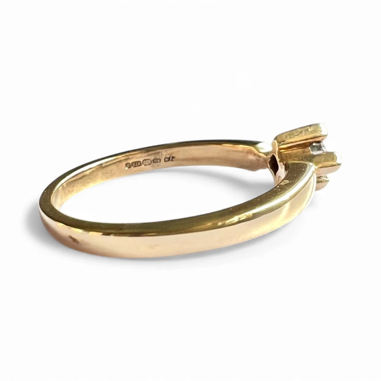 Gold ring with a diamond on a white background. Close up side view 