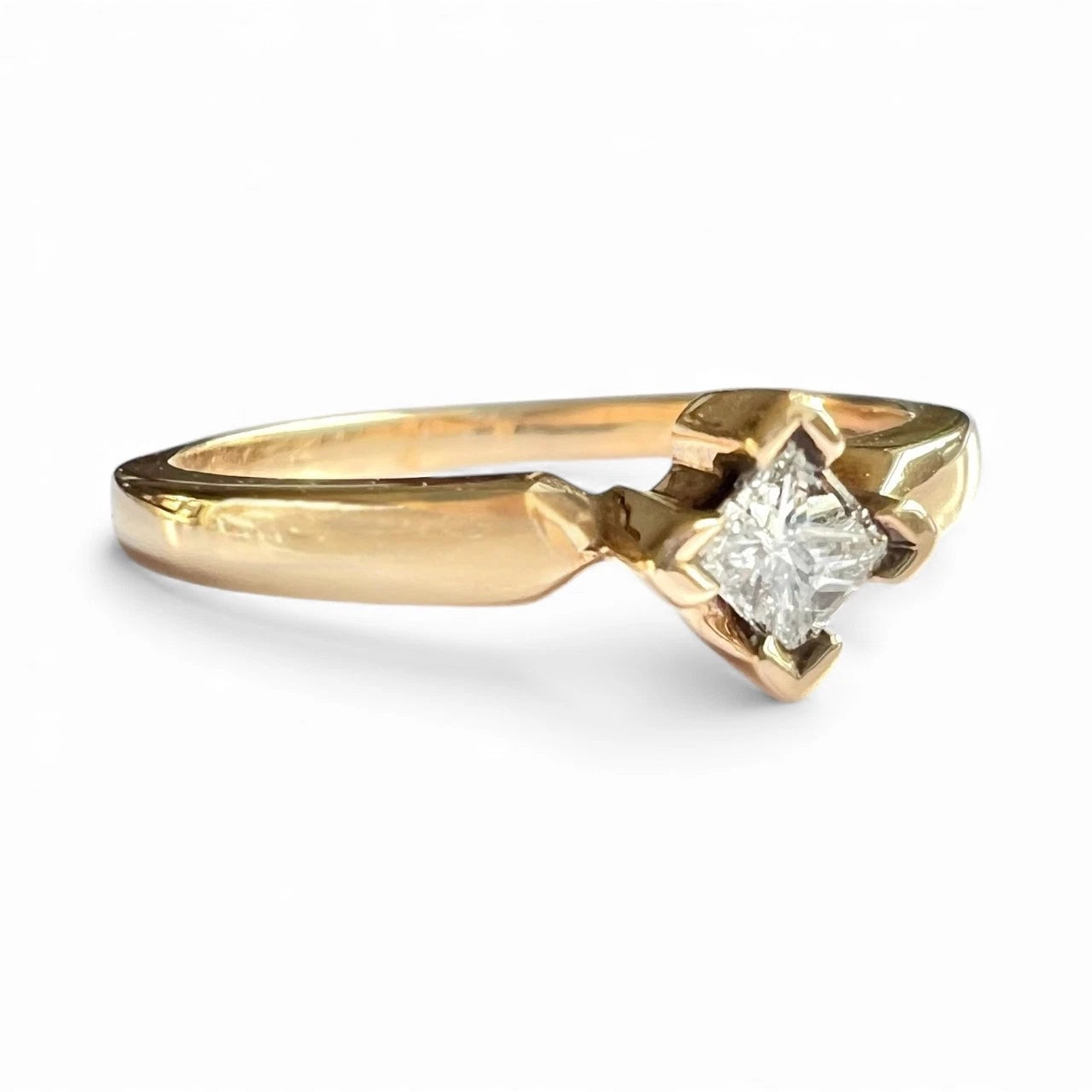 Gold ring with a diamond on a white background