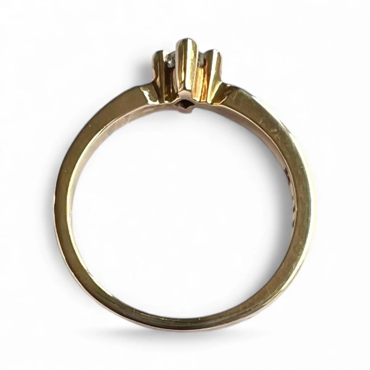 Gold ring with a diamond top on a white background