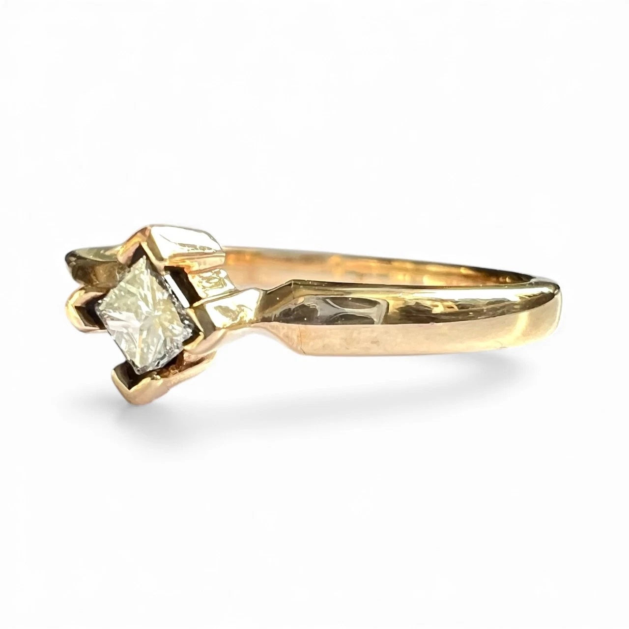 Side view close up gold ring with a diamond on a white background