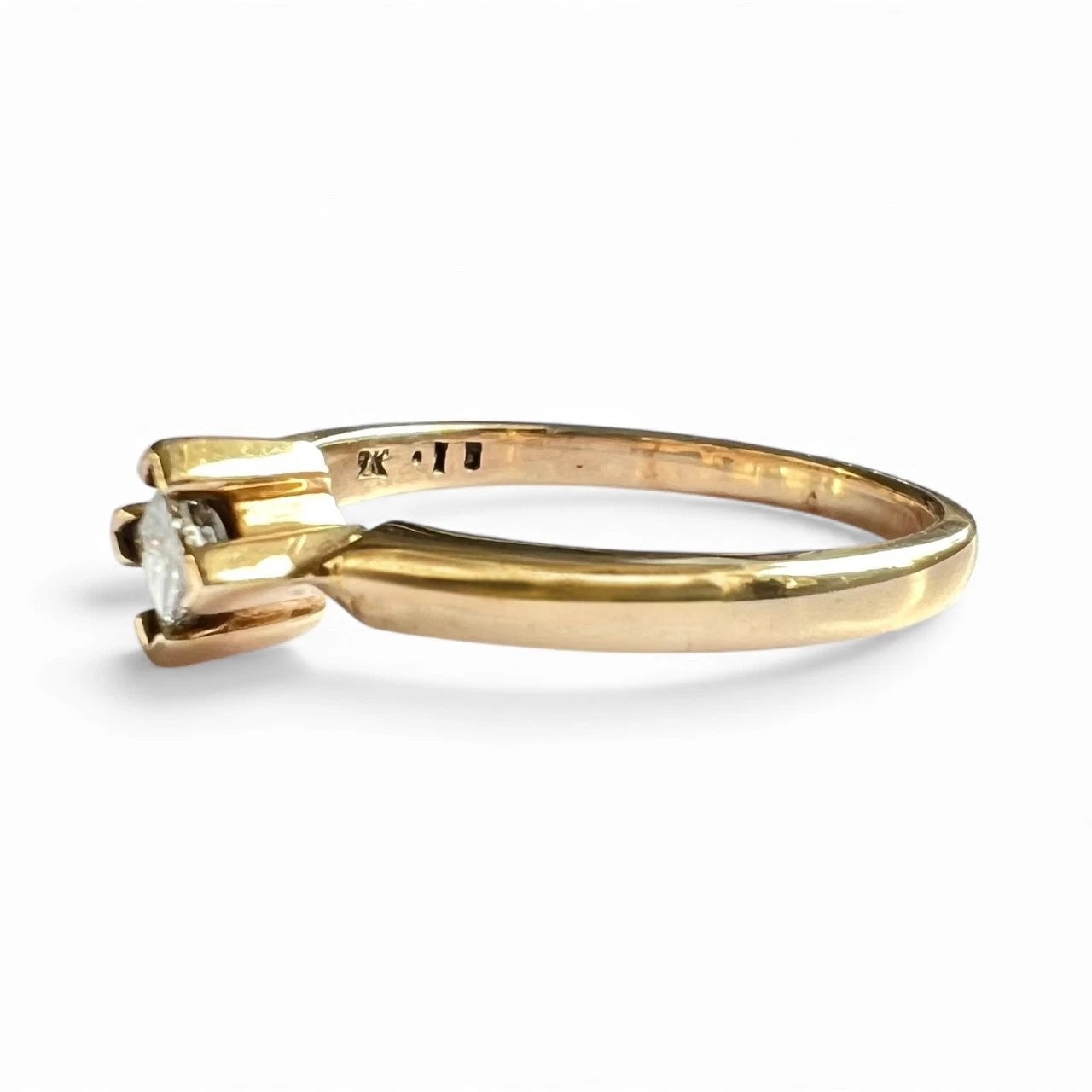 Gold ring with a diamond on a white background