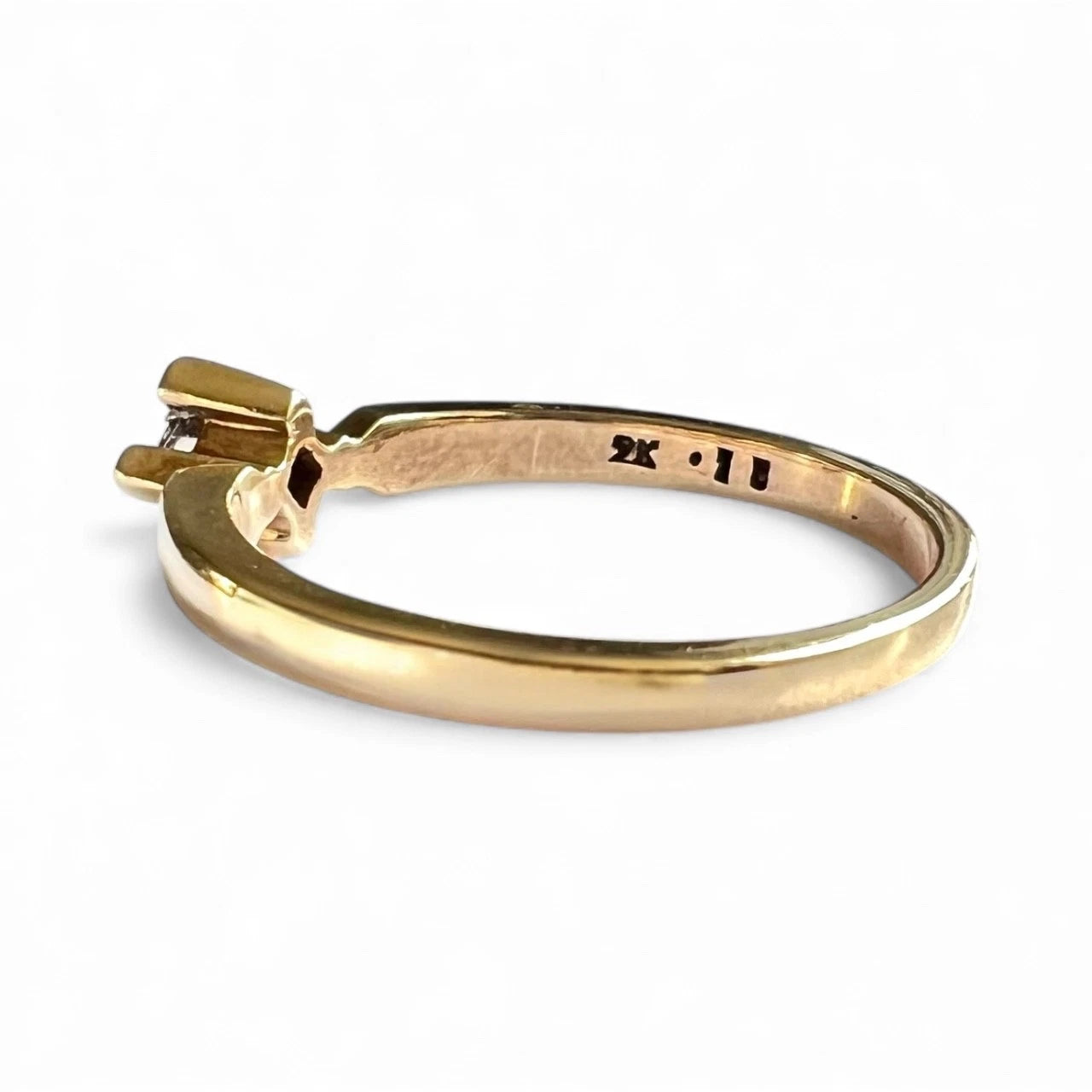 Gold diamond solitaire ring on a white background