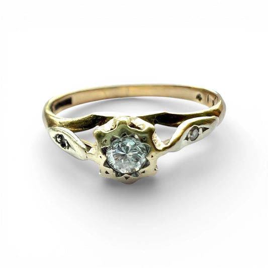 Gold ring with a central diamond and smaller diamonds on a white background close up front view 