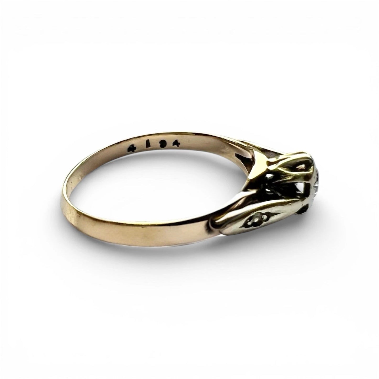 Gold ring with a diamond on a white background side view close up 