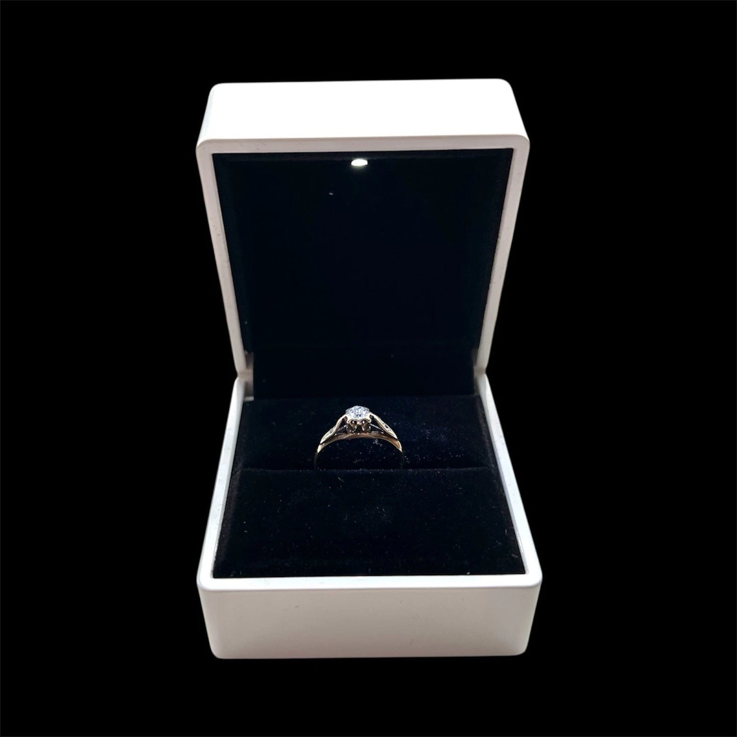 Diamond ring in an open jewellery box on a black background