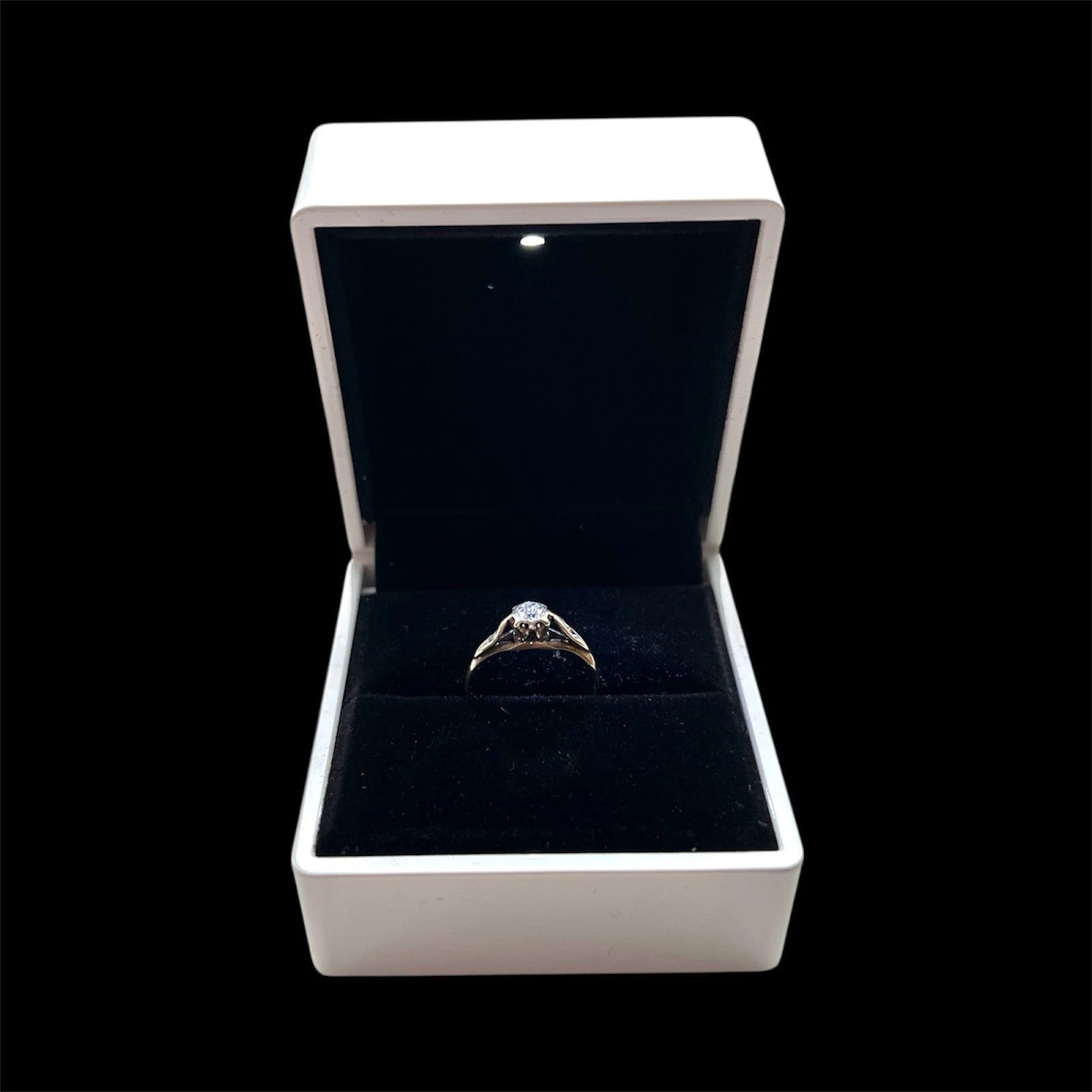 Diamond ring in an open jewellery box on a black background