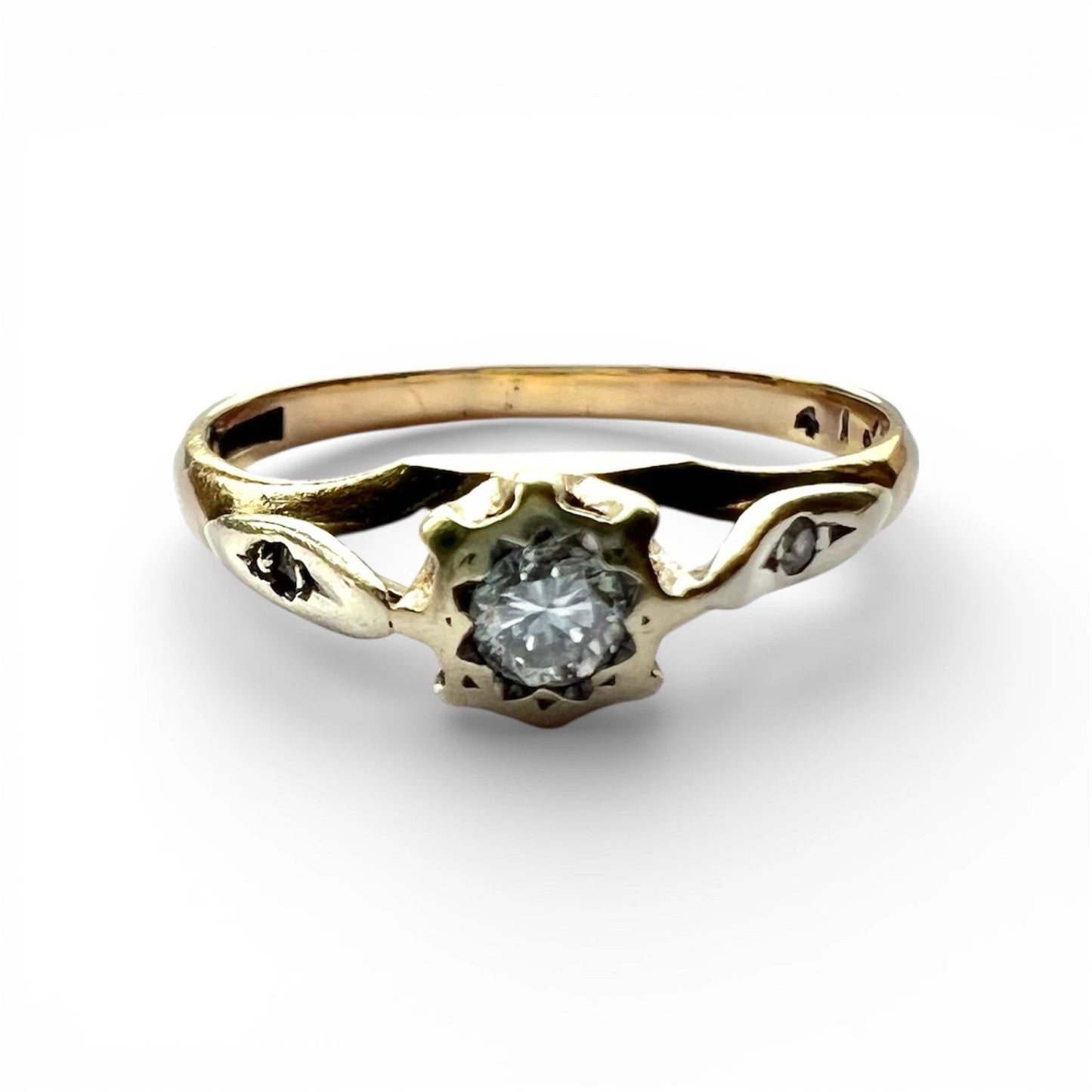 Gold ring with a central diamond and smaller stones close up front view on a white background