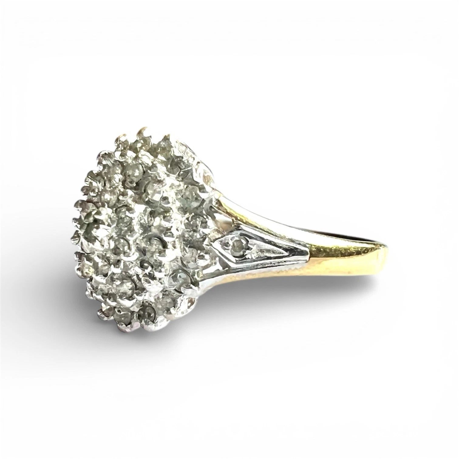 Diamond cluster ring with a white background, close up side view 