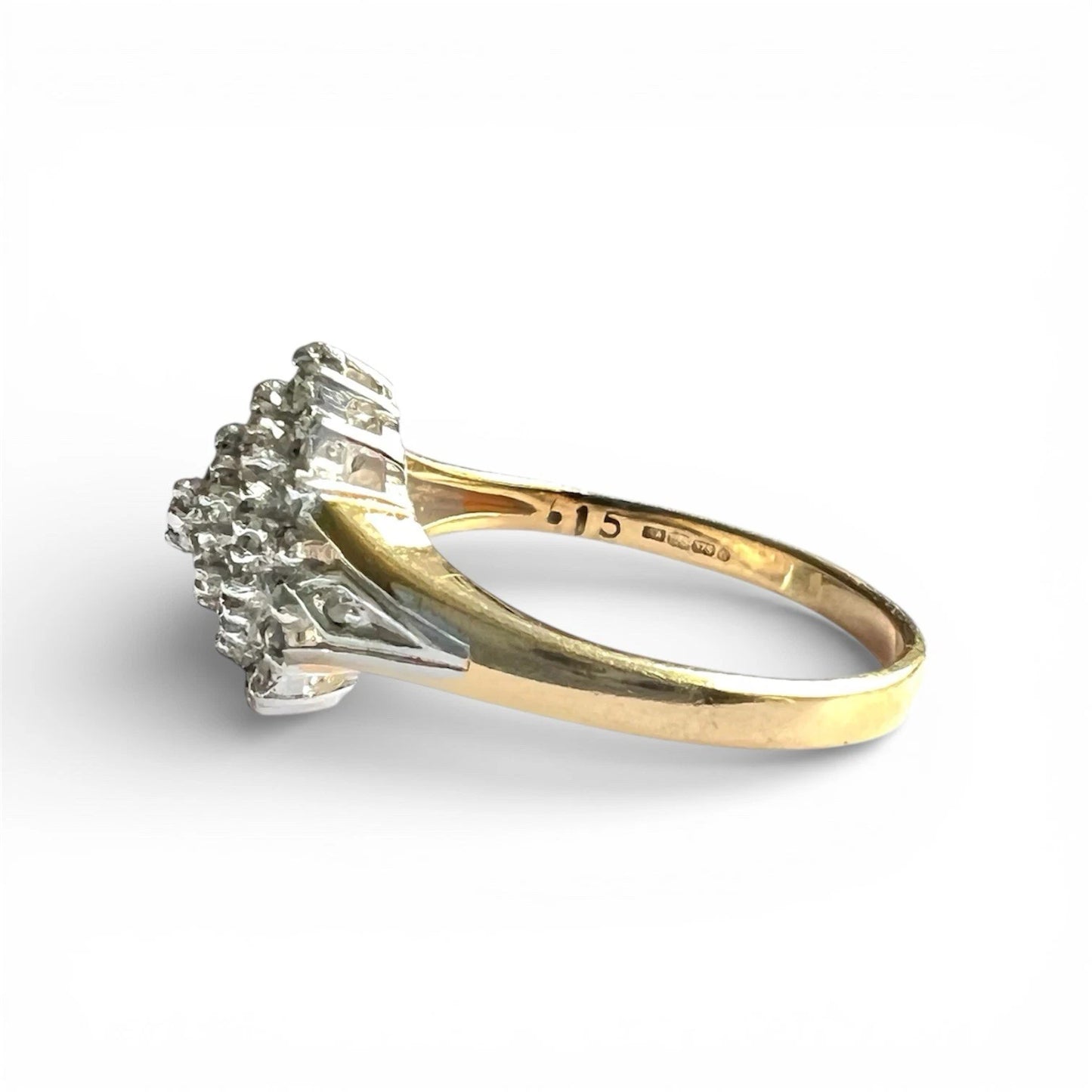 Gold ring with diamond cluster on a white background, close up side view of setting and gold band 