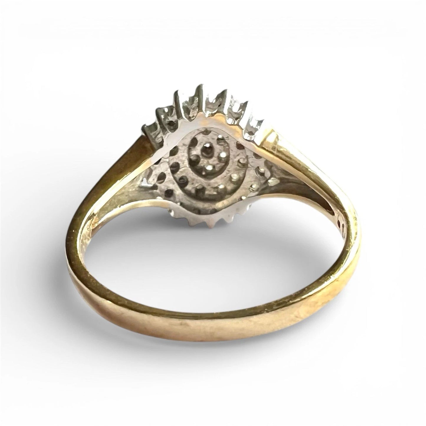 Vintage Gold diamond cluster on a white background, close up rear view of setting and gold band 
