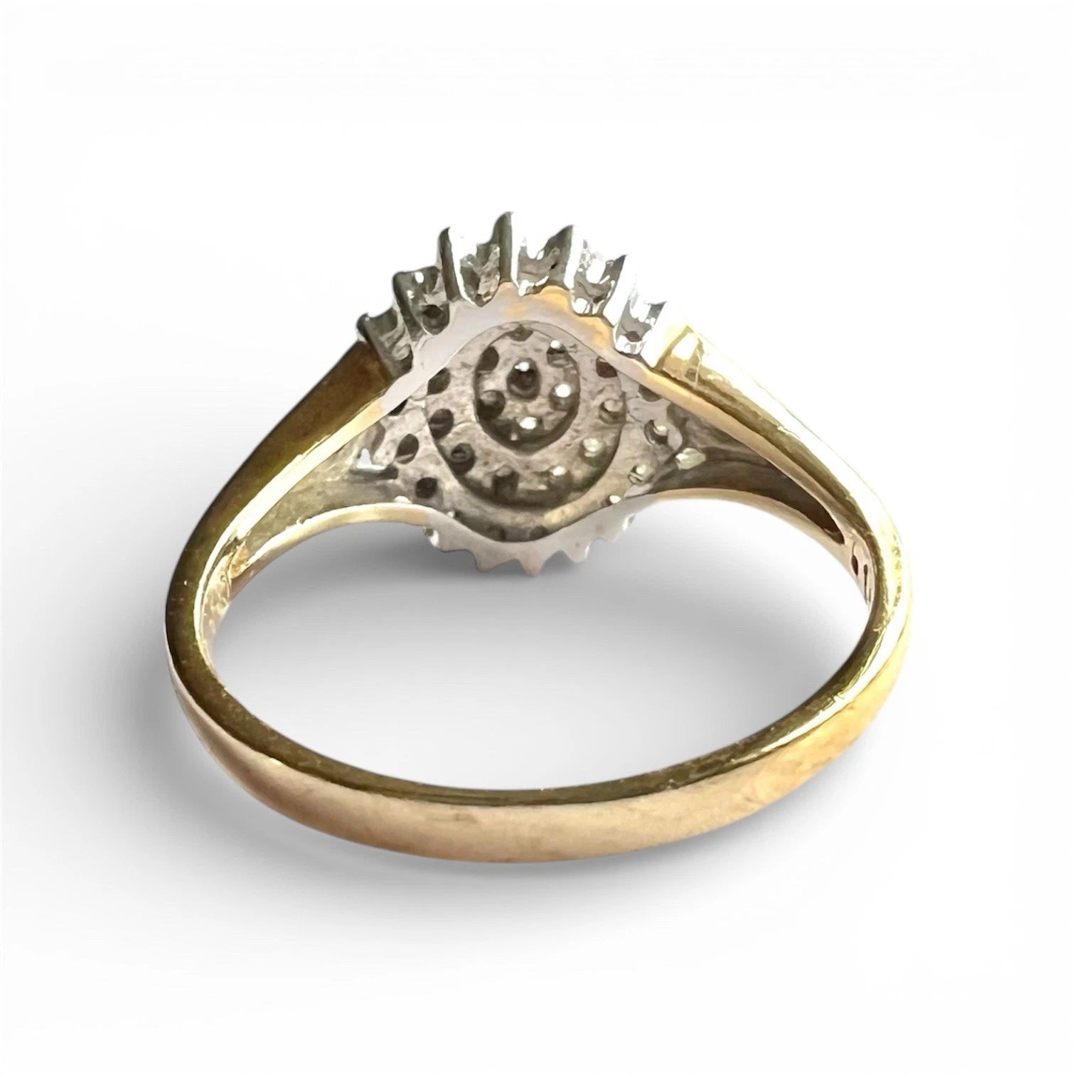 Vintage Gold diamond cluster on a white background, close up rear view of setting and gold band 