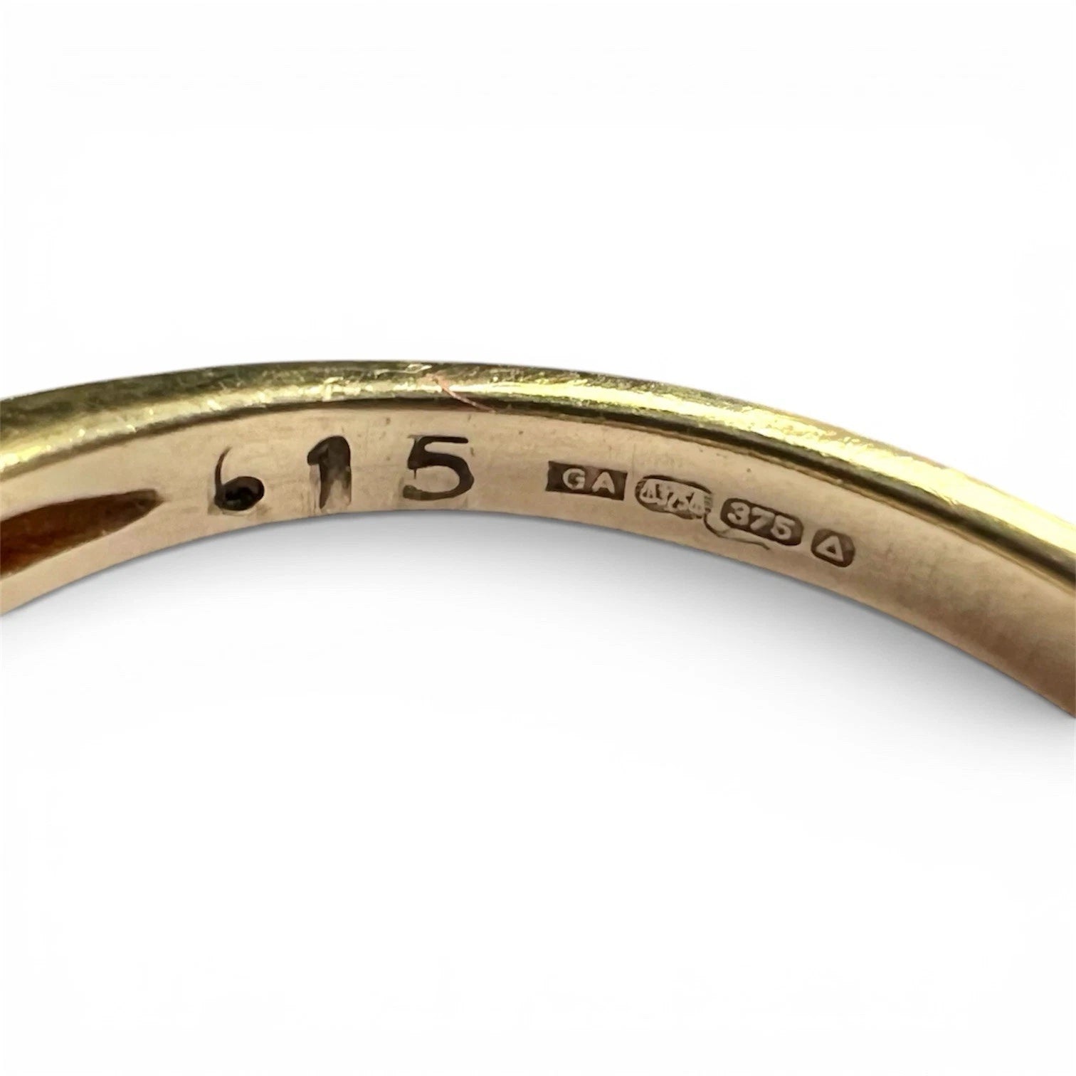 Gold ring with hallmark on a white background