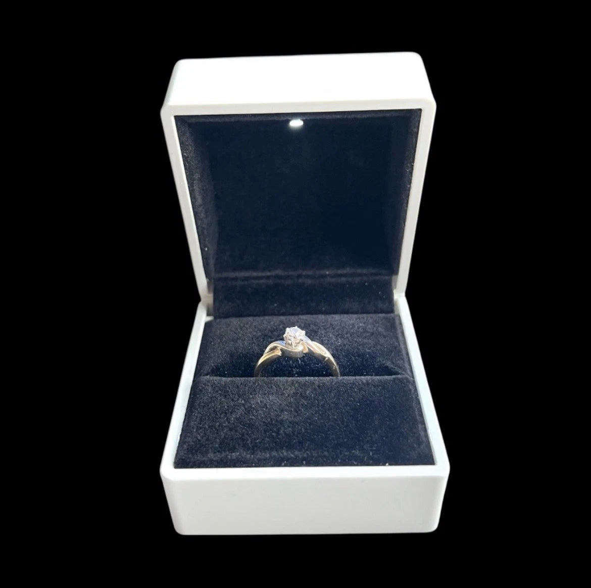 Diamond ring in a white box with a black background