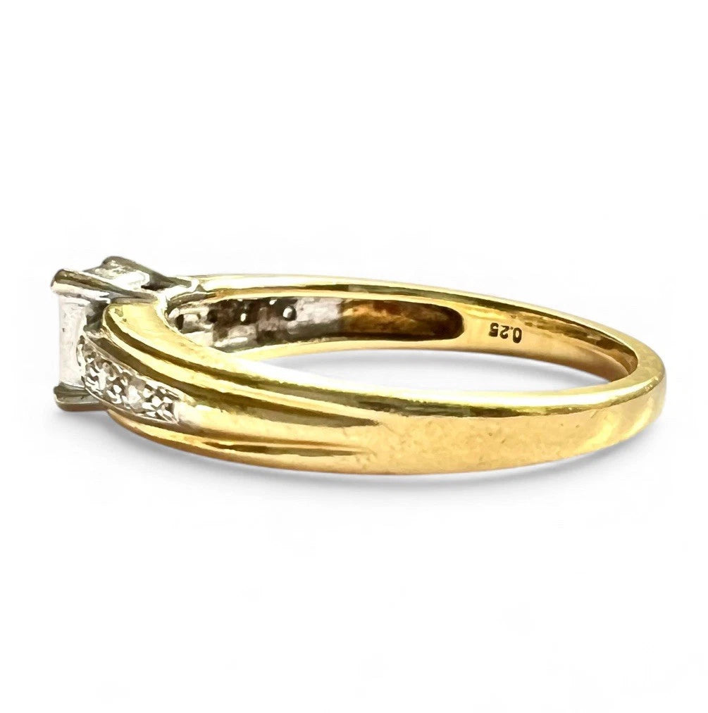 Gold ring with diamond accents on a white background close of of gold band 