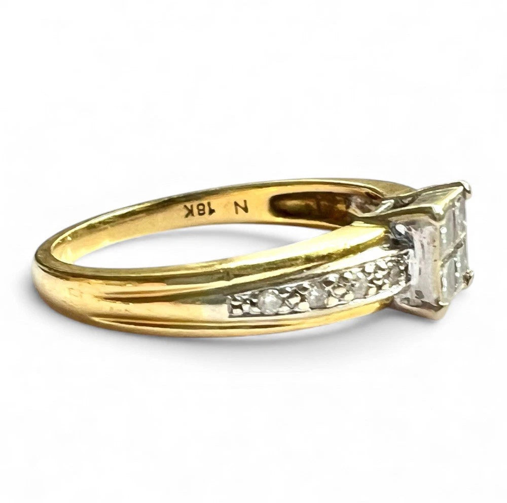Gold ring with diamonds and diamond accents on a white background
