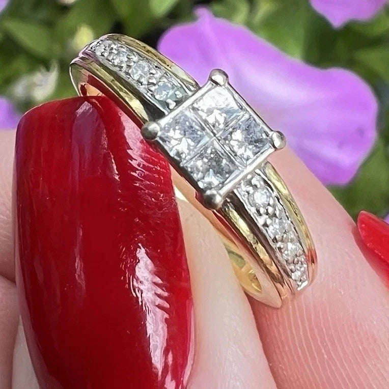 Gold ring with diamonds being held by fingers with red nail polish against a blurred floral background