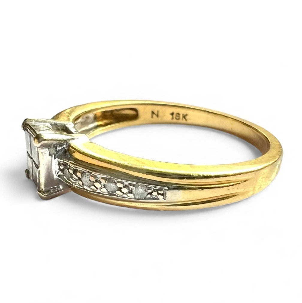 Gold ring with princess cut diamonds and accents on a white background close up side view 