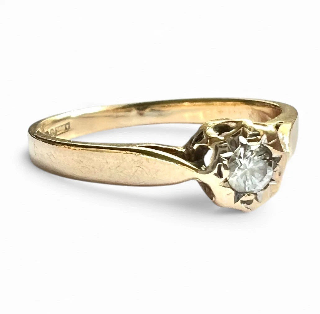 Close up gold ring with a solitaire diamond on a white background