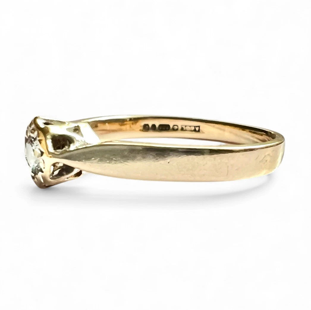 Gold ring with a diamond on a white background. Close up side view 