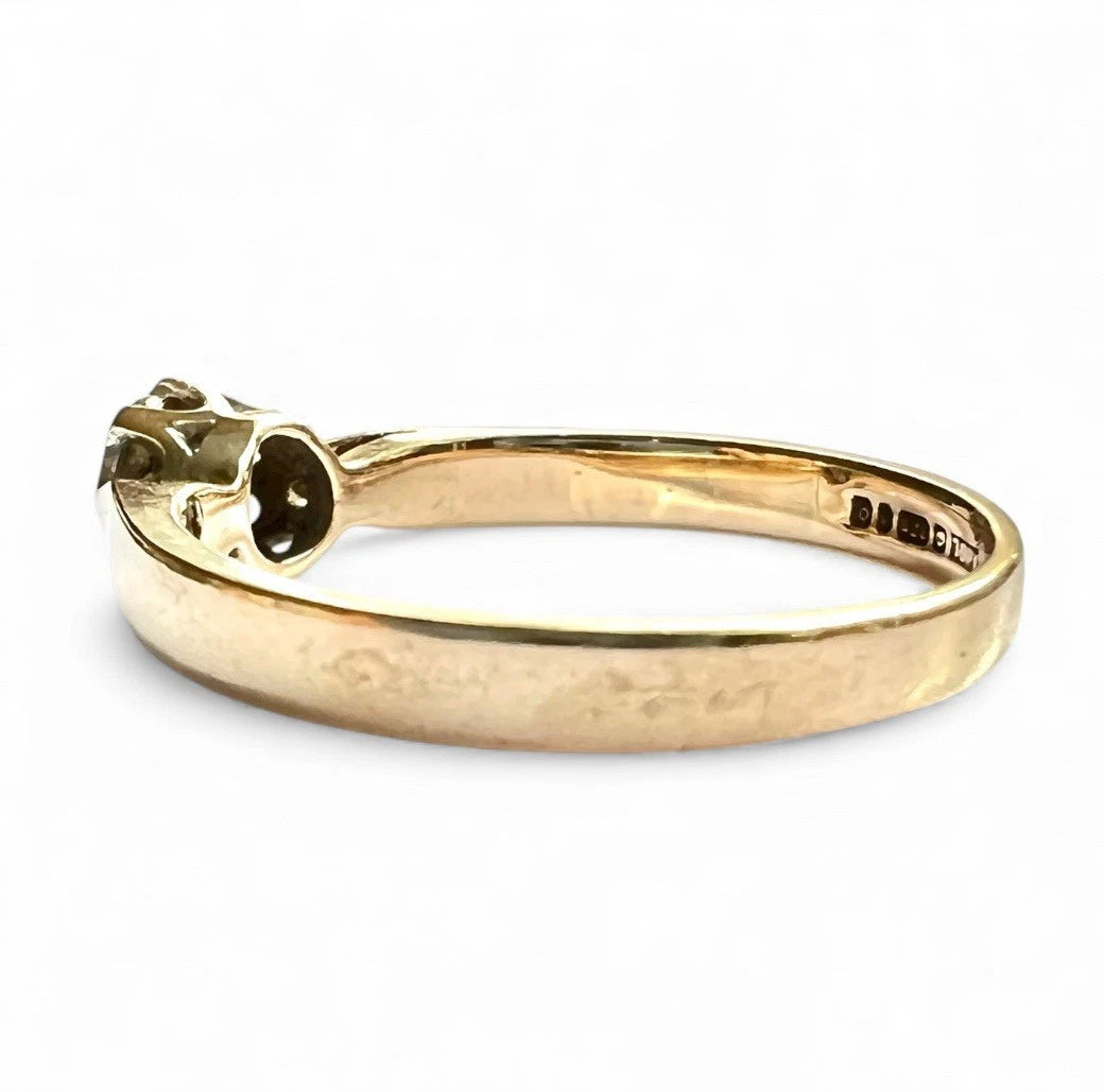 Gold ring with a diamond solitaire on a white background. Close up side view 
