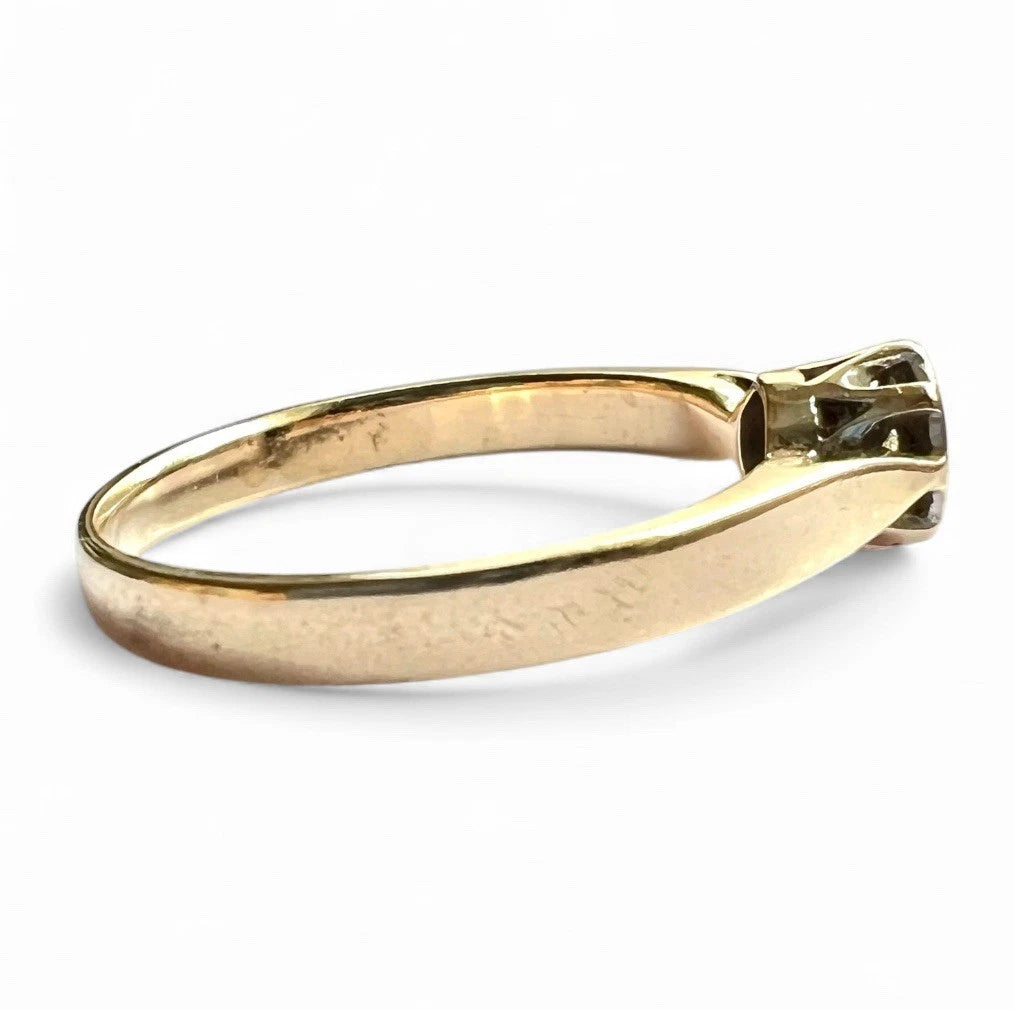 Gold ring with a diamond on a white background