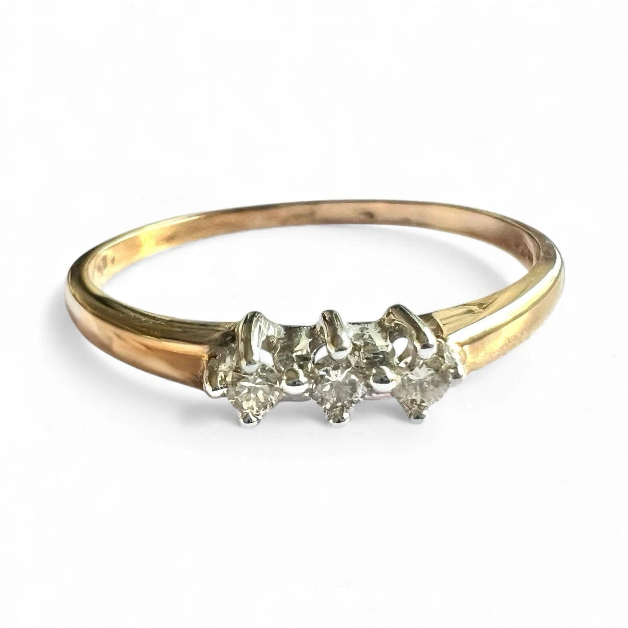 Gold ring with three diamonds on a white background. Close up front view 
