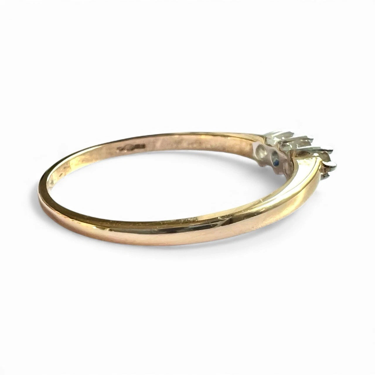 Gold ring with three diamonds on a white background