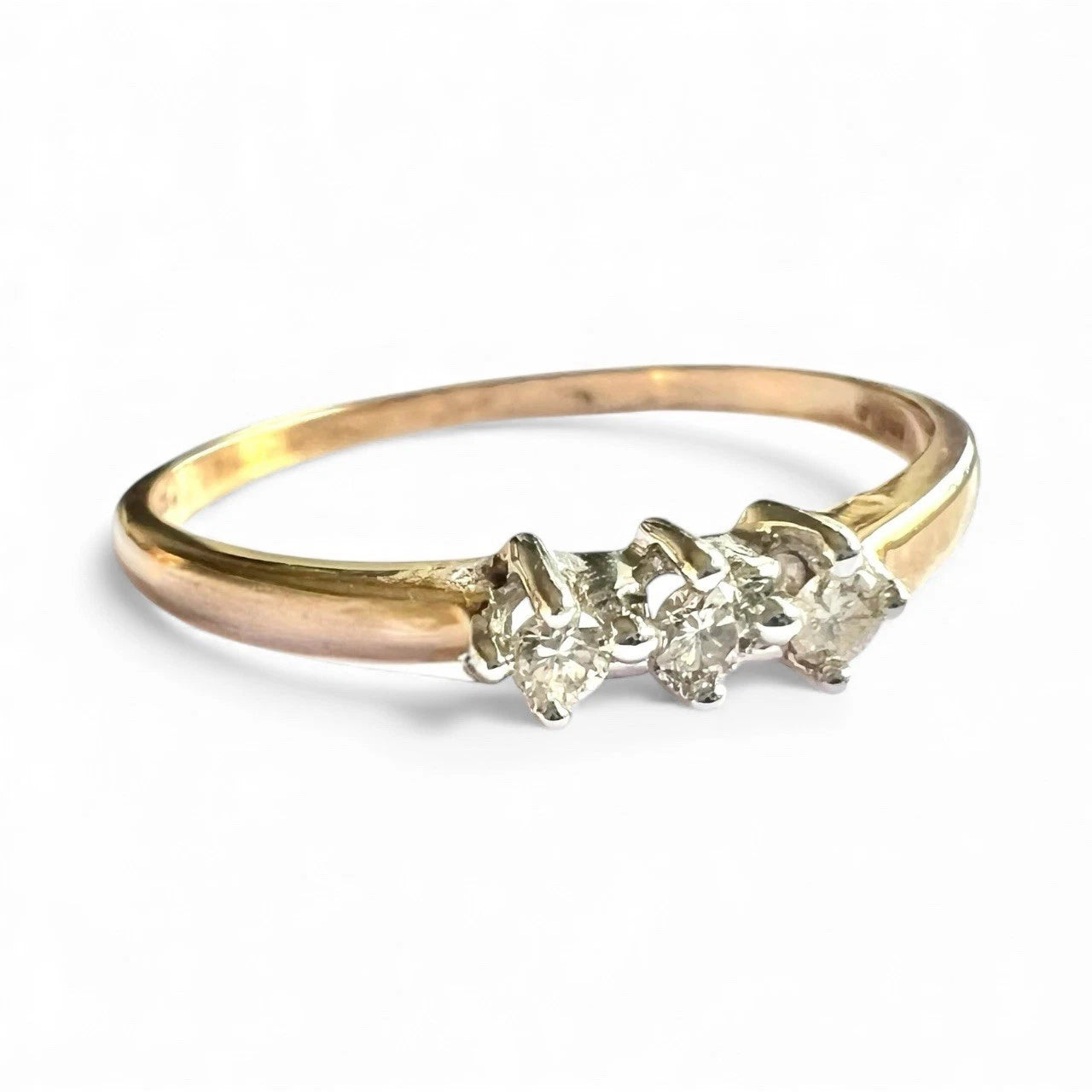 Gold ring with three diamonds on a white background close up front view 