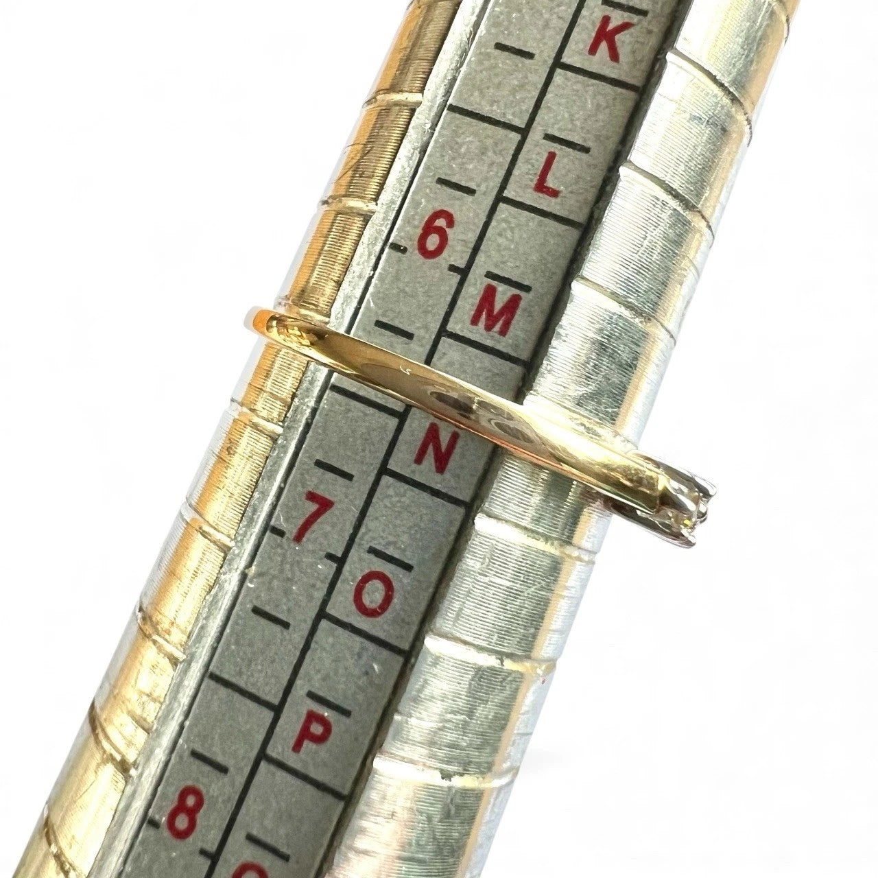 Close-up of a measuring tool with gold ring on a white background