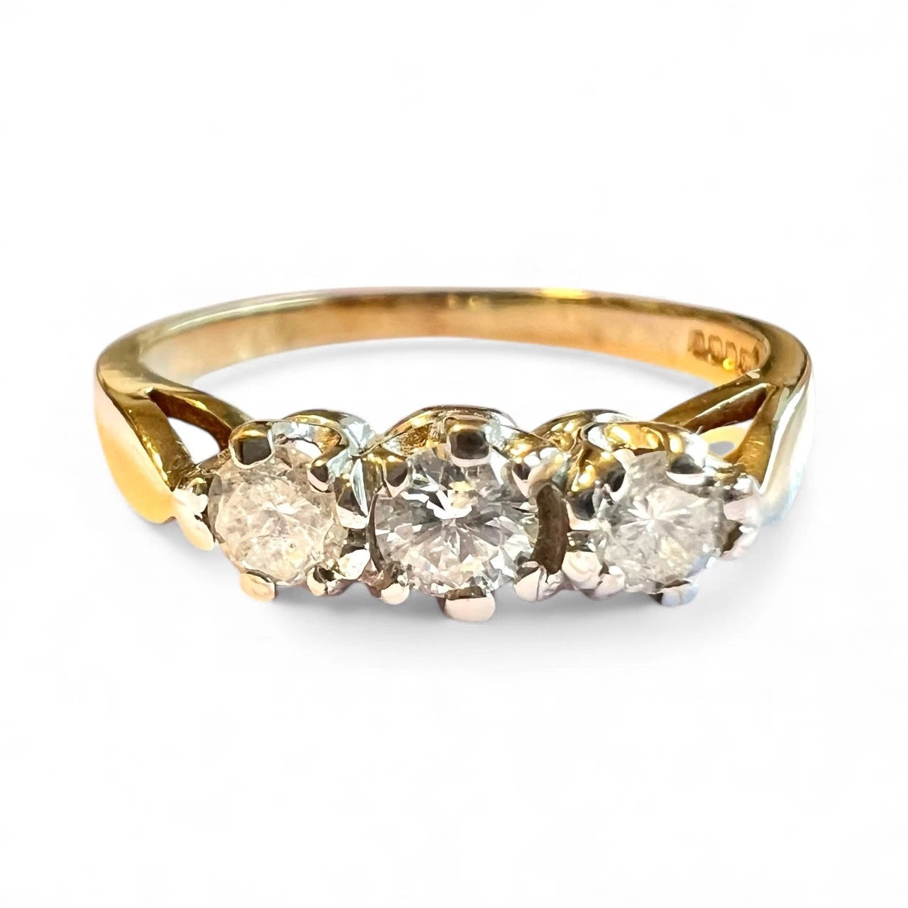 Gold ring with three diamonds on a white background. Close up front view 