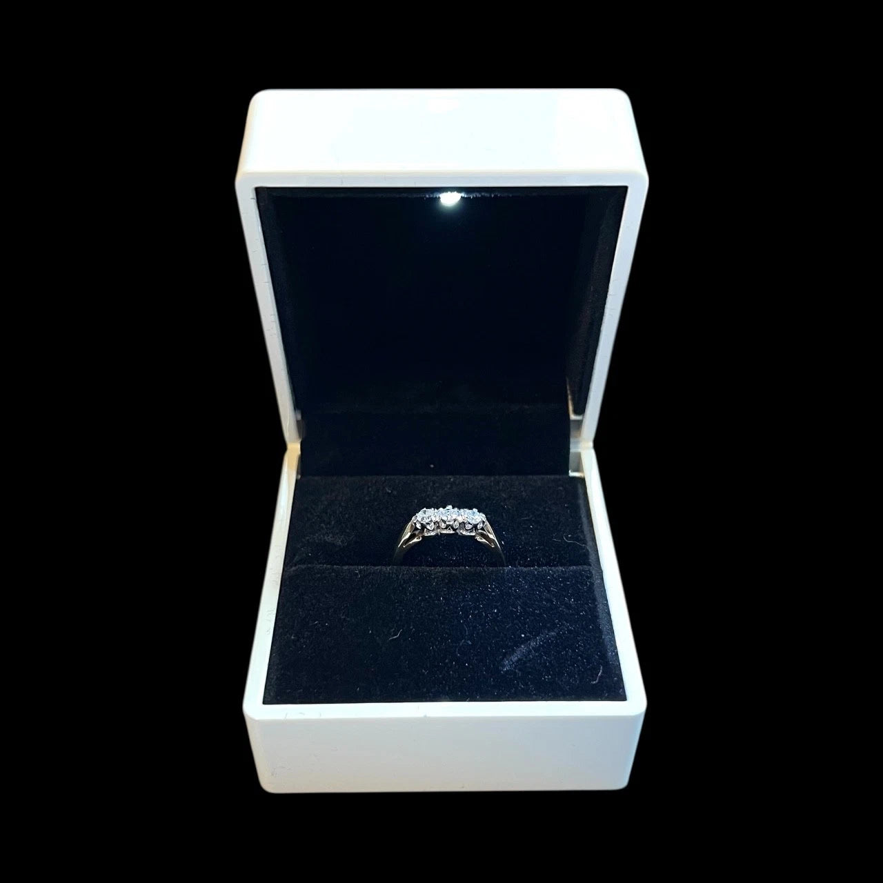 Diamond ring in a white box on a black background