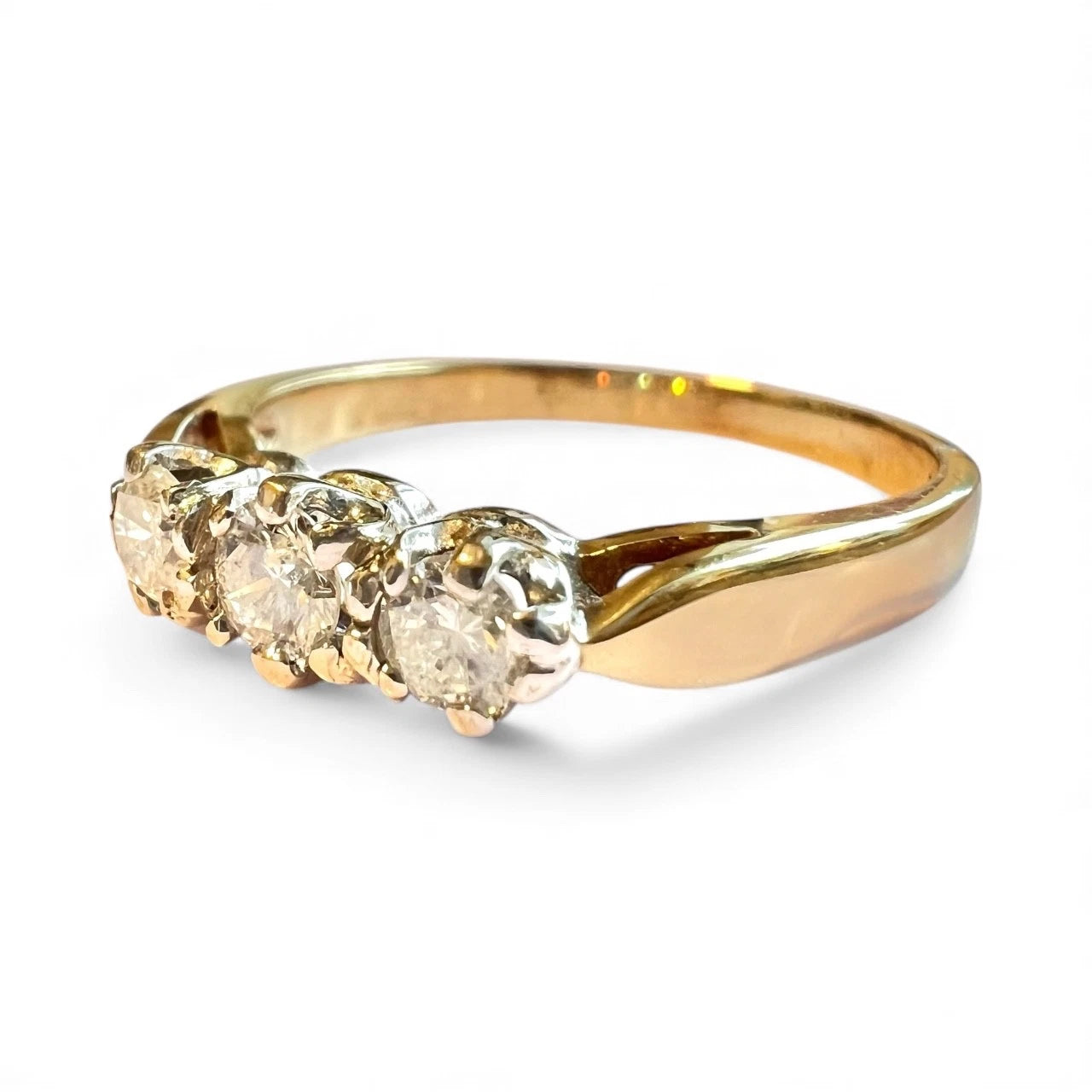 Close up gold ring with three diamonds on a white background