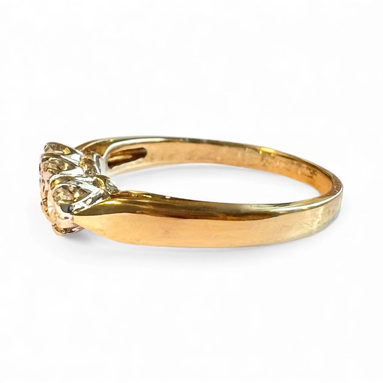 Gold ring with three diamond on a white background. Close up side view 